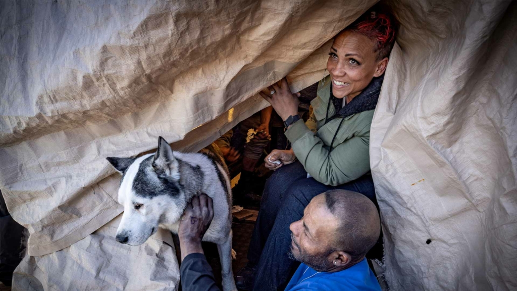 men play with dog and women smiles