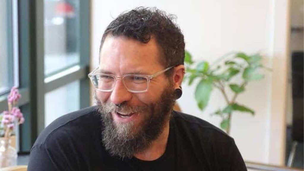 Christopher Archiopoli. White guy with glasses and facial hair, smiling